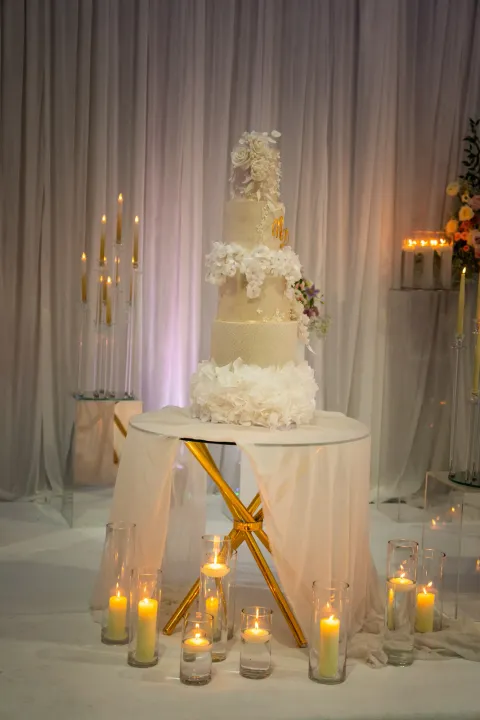 Tiered wedding cake surrounded by candles