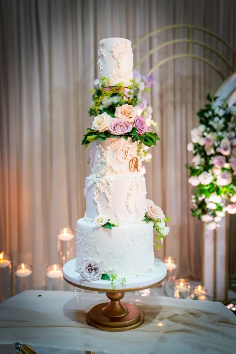 Tall wedding cake decorated with pastel flowers