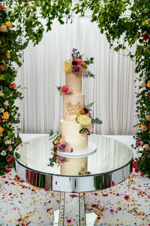 A tiered cake on a mirrored display table
