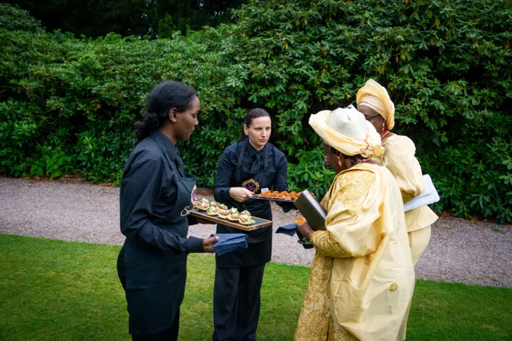 Catering team offering canapés to guests outdoors
