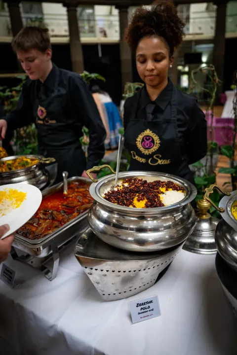 Server tending a polished buffet dish