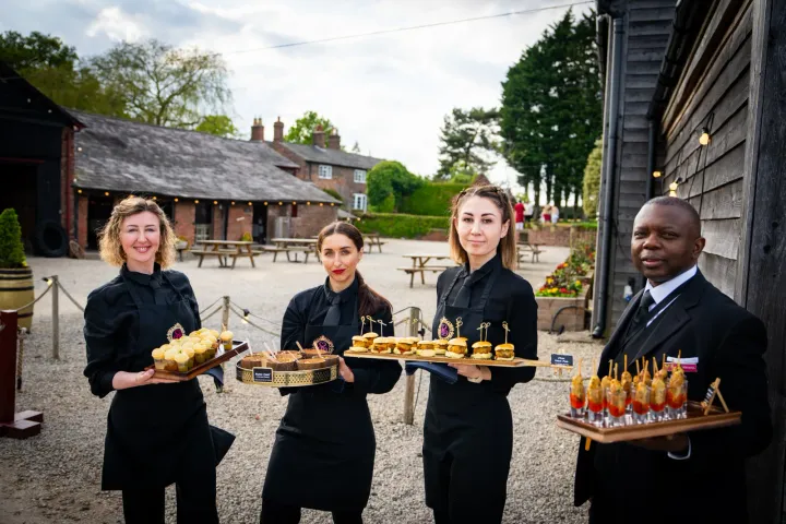 Four team members ready for canapé service outdoors