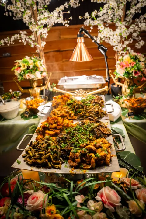 A buffet display framed by flowers and warm lighting