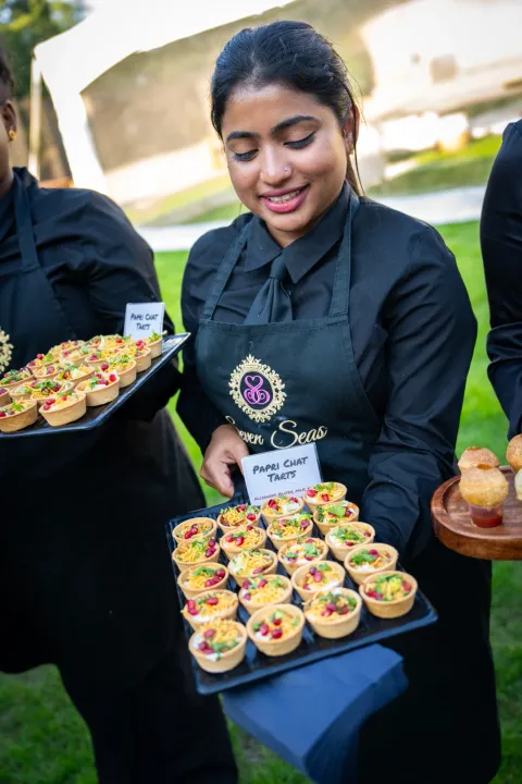 Server offering a tray of small savoury bites