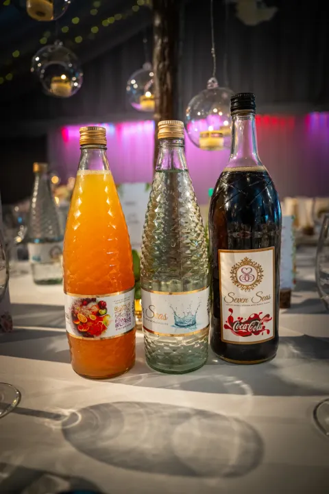 Bottled drinks beside glassware on a table