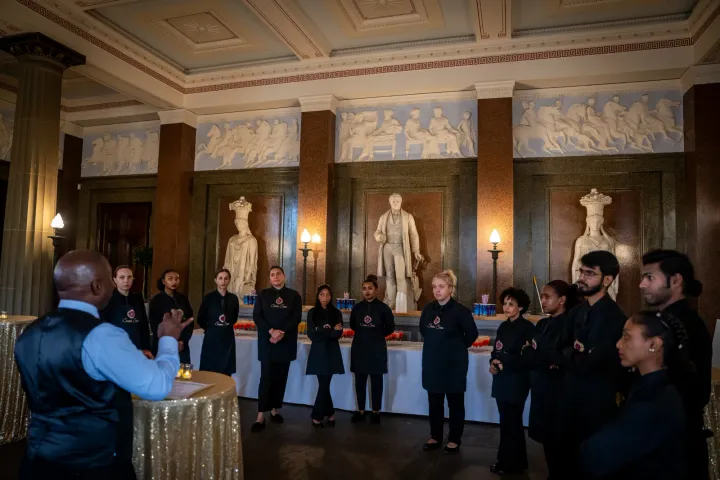 Catering team briefing in an ornate reception room
