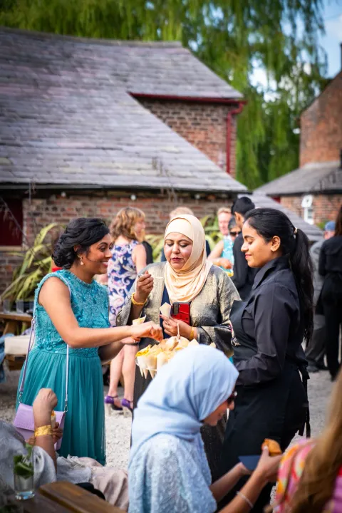 Guests being offered canapés at an outdoor celebration