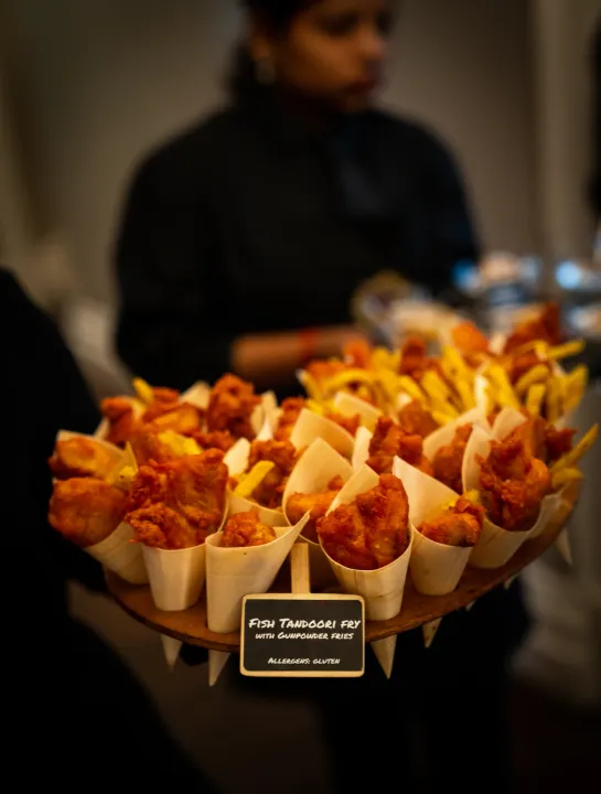 Server carrying cones of golden savoury bites