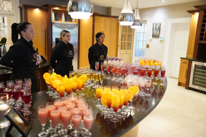 Servers behind a colourful welcome drinks table