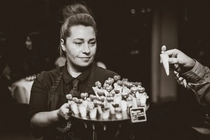 Server offering canapés in a black and white photograph