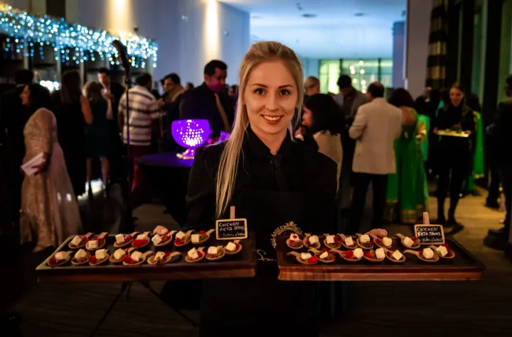 Server presenting two trays of tartlets