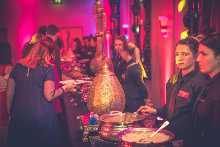 Servers attending a buffet with decorative serving dishes
