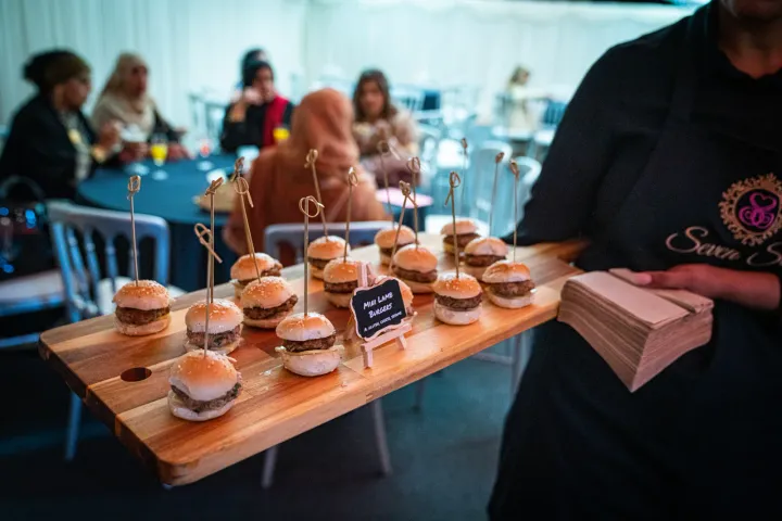 Mini burgers presented on a wooden serving tray