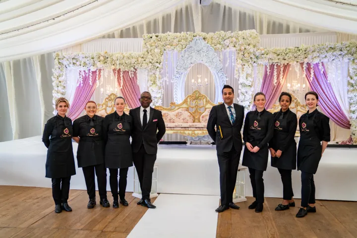 Catering team beside a decorated wedding stage