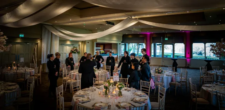 Catering team preparing a dressed reception room