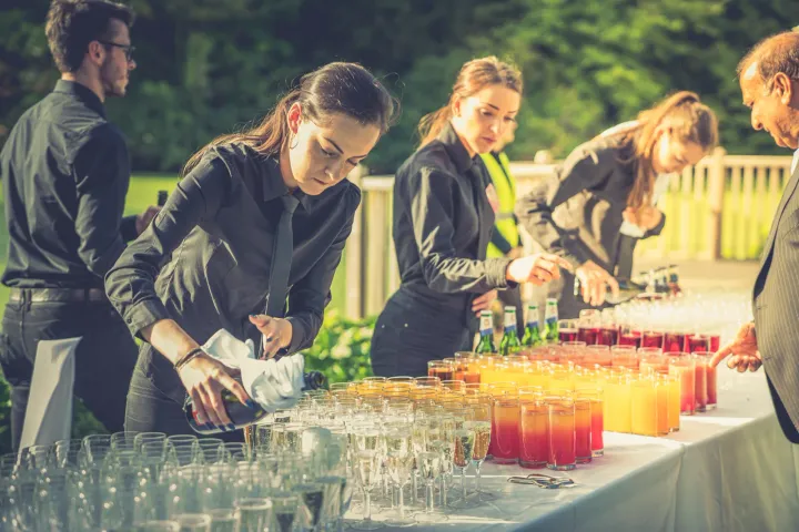 Catering team pouring colourful welcome drinks
