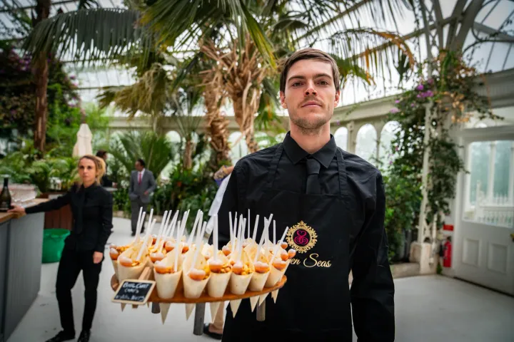 Server presenting savoury cones among tropical plants