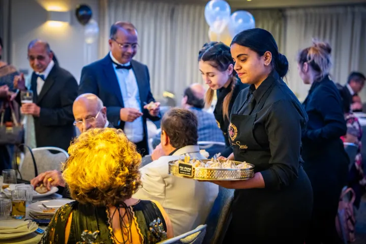 Catering team serving guests at a seated celebration