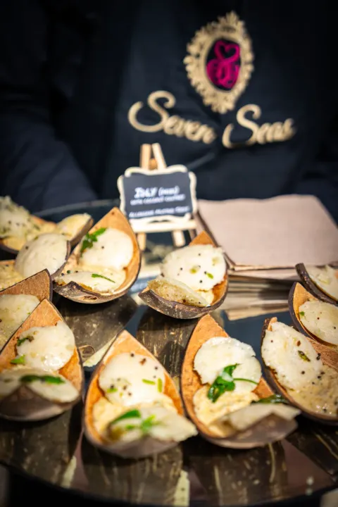 Server presenting individual portions in leaf-shaped bowls