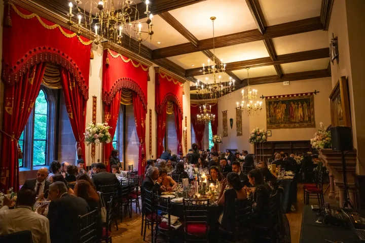 Guests dining beneath chandeliers in a historic room
