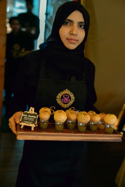 Server presenting gol gappay on a tray