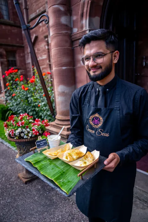 Server carrying mini dosa at a reception