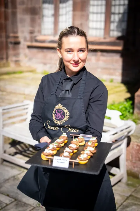 Server presenting tartlets outside a stone venue