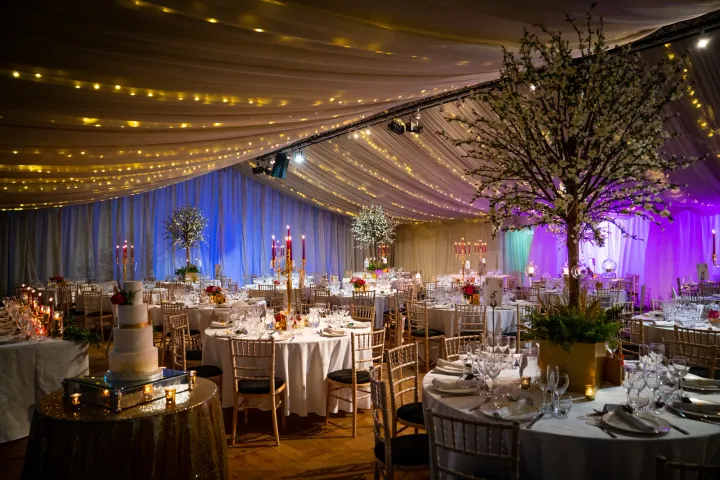 Reception tables beneath golden ceiling lights