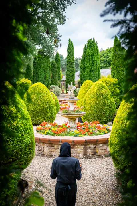 A landscaped garden path leading to an outdoor celebration