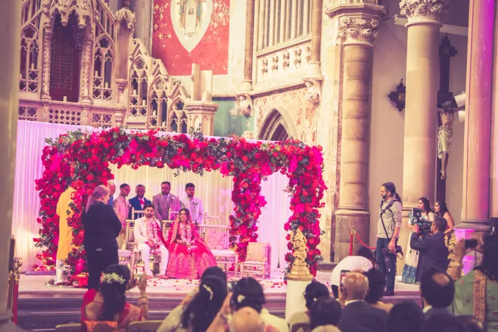 A floral ceremony canopy inside a historic hall