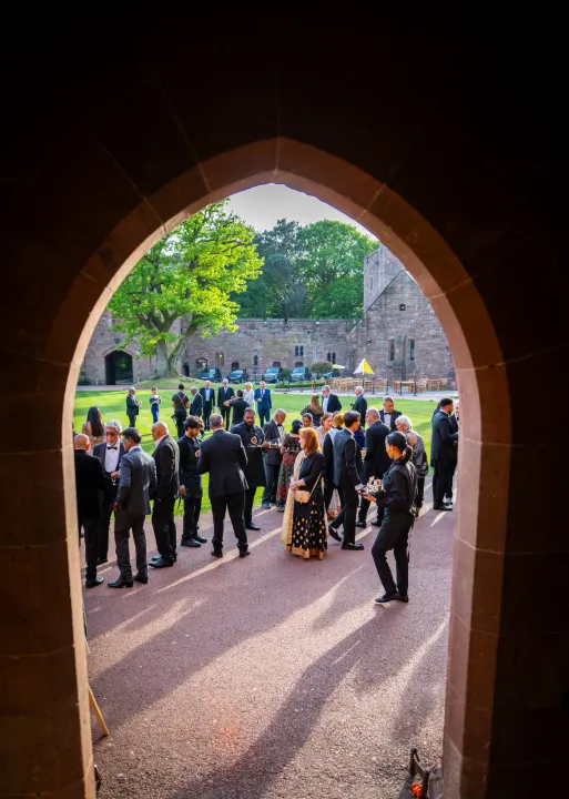 A castle archway framing arriving guests