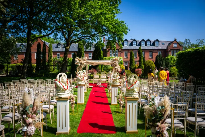 An outdoor ceremony aisle with a red carpet
