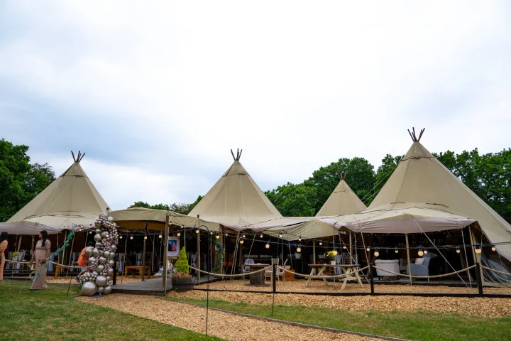 Linked tipis on a grassy event site