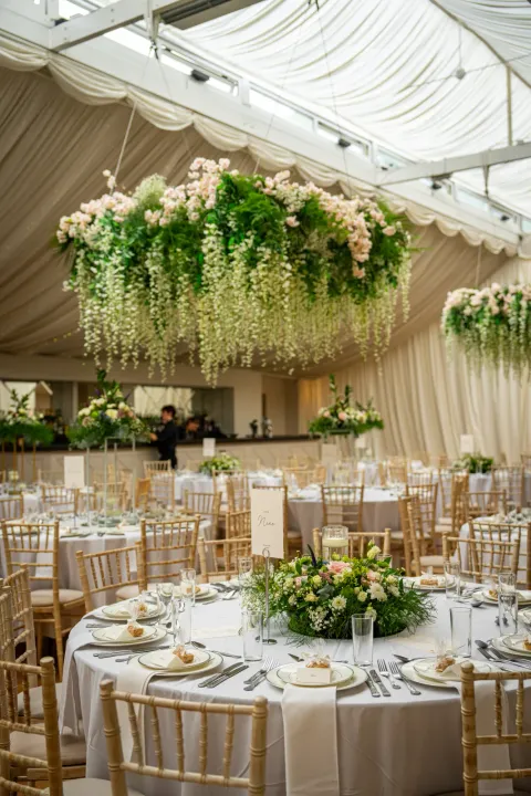 Floral installations above marquee dining tables