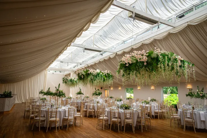 An airy marquee dressed with white flowers and foliage