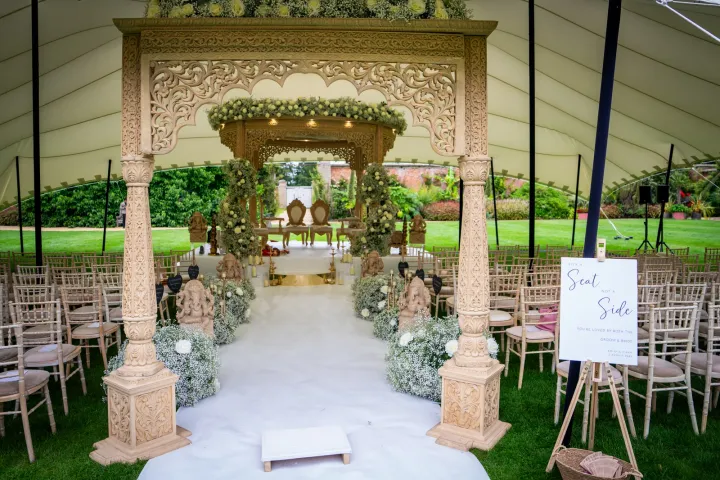 A floral ceremony canopy beneath a marquee roof