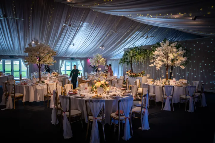 Floral reception tables beneath draped ceilings