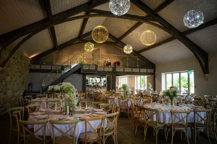 Wedding tables beneath a timber-beamed roof