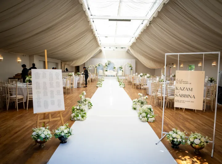 A white ceremony aisle inside a marquee