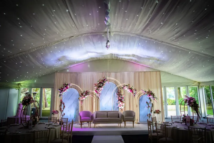 A wedding stage beneath a draped marquee ceiling
