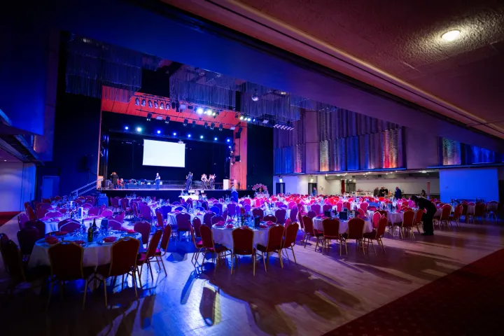 Large event hall with blue stage lighting