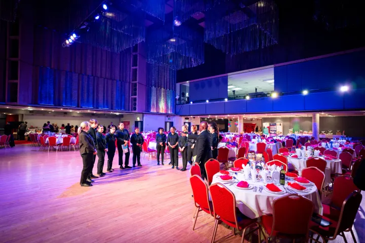 Guests beside reception tables in a large hall