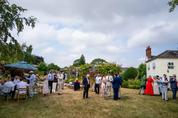 Guests enjoying an outdoor reception beside a country house