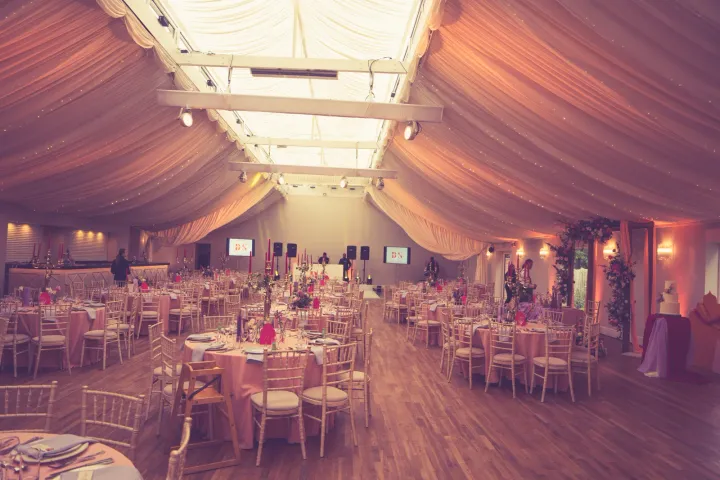 Round tables beneath soft marquee draping