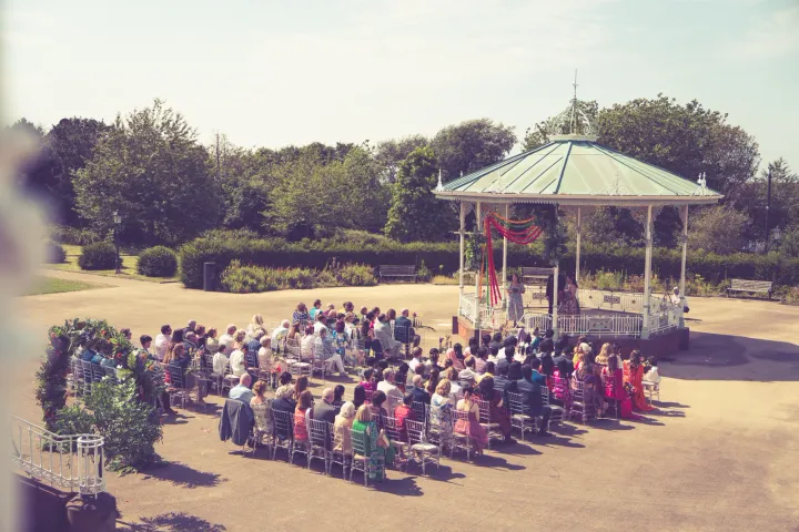 Outdoor wedding ceremony around a garden gazebo