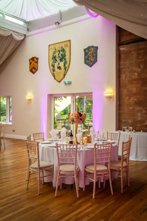Dining tables in a historic room with heraldic shields