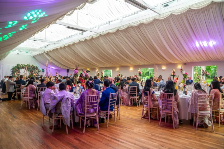 Guests dining in a brightly lit marquee