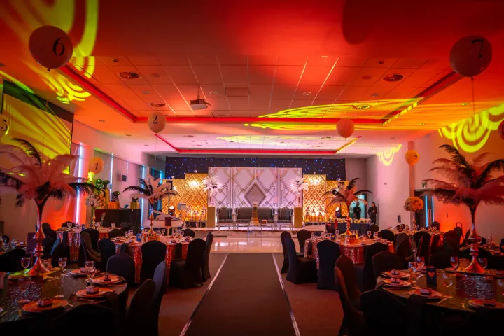 Wedding stage and reception tables under colourful lights
