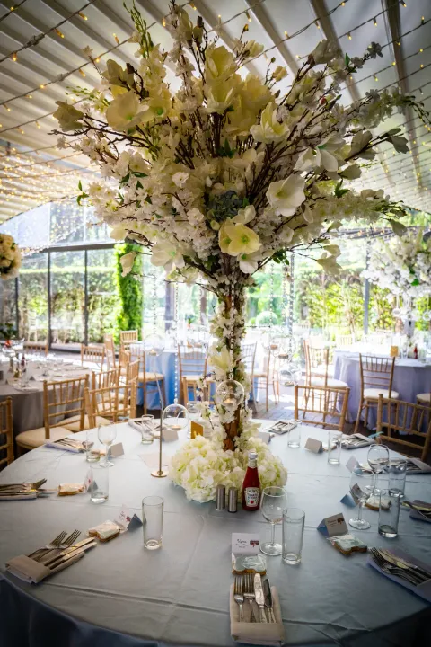 Tall white floral centrepiece on a reception table