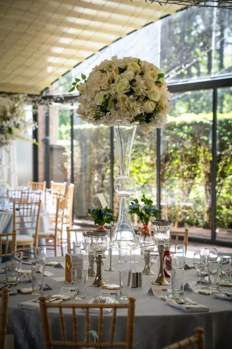 White flowers beside tall reception-room windows
